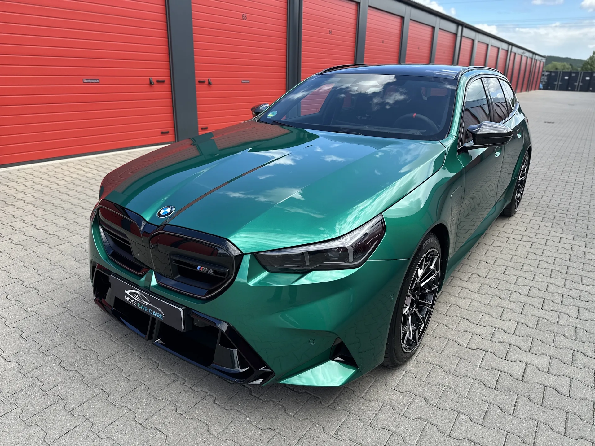 Grüner BMW M5 Touring nach der Fahrzeugaufbereitung vor dem HCC-Studio in Mechernich